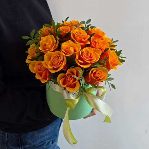 Яркие оранжевые розы Испания в шляпной коробке с зеленью фисташки от интернет-магазина «Чёткий букет» в Воронеже